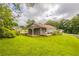 Expansive backyard with lush green grass, mature trees, and covered patio, ideal for outdoor activities at 3217 Canterbury Trl, Rex, GA 30273