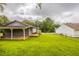 Large, grassy backyard perfect for entertaining, complete with covered patio and mature trees at 3217 Canterbury Trl, Rex, GA 30273