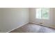 A cozy bedroom features neutral carpet and paint colors and a large standard window for natural light at 3217 Canterbury Trl, Rex, GA 30273