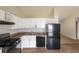 Bright kitchen features white cabinets, black appliances, and wood-look flooring at 3217 Canterbury Trl, Rex, GA 30273