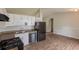 Bright kitchen features white cabinets, black appliances, and wood-look flooring at 3217 Canterbury Trl, Rex, GA 30273
