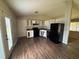 A kitchen featuring white cabinets and dark appliances with modern flooring and a door leading to the outside at 3217 Canterbury Trl, Rex, GA 30273