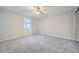 Spacious bedroom with plush carpet, a ceiling fan, and a large window for natural light at 6118 Dana Ct, Lithonia, GA 30058