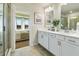 Bright bathroom with double sinks, white cabinetry, and a clear view of main bedroom at 6137 Wayburn St, Tucker, GA 30084