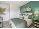 Bright bedroom with a deep green accent wall, light furniture, and matching decor at 6137 Wayburn St, Tucker, GA 30084