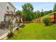 Spacious backyard with a well-maintained lawn, a covered patio, and tall trees offering plenty of shade at 872 Misty View Ct, Lilburn, GA 30047
