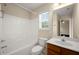 Bathroom with tub and shower combo, toilet, a window, and vanity; view to bedroom at 872 Misty View Ct, Lilburn, GA 30047