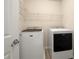 Compact laundry room with new, modern washer and dryer machines and wire rack shelving at 872 Misty View Ct, Lilburn, GA 30047