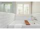 Bright bathroom showcasing a soaking tub, stylish wall tiling and natural light at 1555 Steele Nw Dr, Atlanta, GA 30309