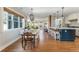Spacious dining room and kitchen area, featuring hardwood floors, a wooden table, and an island with bar stools at 1555 Steele Nw Dr, Atlanta, GA 30309