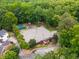 Overhead shot of community sports court, playground, and manicured green spaces surrounded by trees at 3786 Turnberry Ct, Duluth, GA 30096
