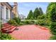 Exterior view features a large brick patio surrounded by lush landscaping at 3786 Turnberry Ct, Duluth, GA 30096