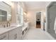 Bright bathroom featuring double sinks, shower, and marble floors at 3786 Turnberry Ct, Duluth, GA 30096