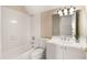 Bright bathroom featuring a white vanity with a large mirror and shower-tub combination at 3786 Turnberry Ct, Duluth, GA 30096