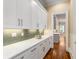 Butler's pantry with white cabinets, quartz countertops, and a decorative tile backsplash at 3786 Turnberry Ct, Duluth, GA 30096