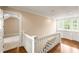 Upstairs hallway with bright natural light and hardwood floors at 3786 Turnberry Ct, Duluth, GA 30096