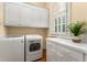 Laundry room featuring modern washer and dryer, counter space, and storage at 3786 Turnberry Ct, Duluth, GA 30096