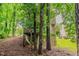 Backyard view of a two-story house with a deck, surrounded by mature trees providing shade and privacy at 5073 Leland Dr, Stone Mountain, GA 30083