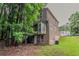 Exterior side view of a two-story house, featuring wood siding and mature trees, offering a serene and private setting at 5073 Leland Dr, Stone Mountain, GA 30083