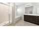 Bright bathroom featuring a glass-enclosed shower, separate tub, and dark-stained wood vanity at 7644 Rudder Cir, Fairburn, GA 30213