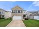 Two-story brick home with a two car garage and a well manicured lawn on a bright sunny day at 7644 Rudder Cir, Fairburn, GA 30213