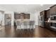Spacious, open-concept kitchen with dark wood cabinets, stainless steel appliances, and bar stool seating at 7644 Rudder Cir, Fairburn, GA 30213