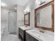 Bright bathroom with double sink vanity, framed mirrors, shiplap accent wall, and a glass enclosed shower at 793 Inman Mews Ne Dr, Atlanta, GA 30307