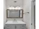 Upgraded bathroom featuring a modern vanity with a gray cabinet, quartz countertop, framed mirror, and sconce lighting at 793 Inman Mews Ne Dr, Atlanta, GA 30307