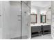 Bright bathroom featuring double sink vanity, framed mirrors, shiplap accent wall, and glass enclosed shower at 793 Inman Mews Ne Dr, Atlanta, GA 30307