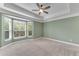 A bright bedroom featuring neutral carpet, a tray ceiling with fan, and a bay window with view at 793 Inman Mews Ne Dr, Atlanta, GA 30307
