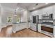 Open-concept kitchen with island, stainless appliances, and stylish lighting at 793 Inman Mews Ne Dr, Atlanta, GA 30307