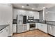Modern kitchen featuring white cabinets, stainless steel appliances, granite countertops, and a light grey backsplash at 793 Inman Mews Ne Dr, Atlanta, GA 30307