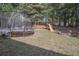 View of the grassy backyard with a trampoline, swing set, and fire pit, perfect for outdoor fun at 25 Nunnally Pl, Villa Rica, GA 30180