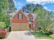 Beautiful brick home with a well-manicured lawn, two-car garage, and charming front yard landscaping at 25 Nunnally Pl, Villa Rica, GA 30180