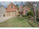 Lovely red brick two-story home with two-car garage and a well-kept front lawn with mature landscaping at 25 Nunnally Pl, Villa Rica, GA 30180