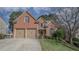 Brick home with well-maintained lawn, two-car garage, and mature landscaping on a sunny day at 25 Nunnally Pl, Villa Rica, GA 30180