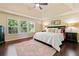 Large bedroom featuring hardwood floors, natural light, and decorative lamps at 5285 Winflow Way, Suwanee, GA 30024