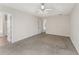Large main bedroom featuring a tray ceiling, ceiling fan, carpet flooring, and two entry doors at 5960 Castlegate Dr, Douglasville, GA 30135