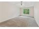 Spacious main bedroom with a ceiling fan, a large window, and neutral-colored carpet at 5960 Castlegate Dr, Douglasville, GA 30135