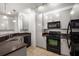 Bright kitchen featuring white cabinets, black appliances, and track lighting at 400 17Th Nw St # 2308, Atlanta, GA 30363