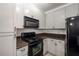 Bright kitchen featuring white cabinets, black appliances, and stylish countertops at 400 17Th Nw St # 2308, Atlanta, GA 30363