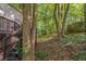 Wooded backyard with mature trees and the house features a back deck with stairs at 402 John Tate Nw Rd, Acworth, GA 30102