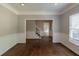 Open living room with hardwood floors and white trim, offering a view of the staircase at 402 John Tate Nw Rd, Acworth, GA 30102