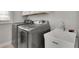 Modern laundry room featuring front loading washer and dryer with sink and a window at 545 Hanlon Way, Alpharetta, GA 30009