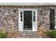 Close-up of a black front door with sidelights, framed by brick and adorned with elegant sconces at , Dunwoody, GA 30338