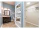 Bathroom with blue walls, stylish vanity, built-in shelving, and convenient walk-in closet at 496 Rankin Ne St, Atlanta, GA 30308