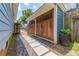 View of the detached garage boasting stunning wooden doors and accented by stone pavers and stylish greenery at 496 Rankin Ne St, Atlanta, GA 30308