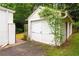 Detached garage with white doors and mature landscaping at 657 E Paces Ferry Ne Rd, Atlanta, GA 30305