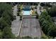 An aerial view of a pool, tennis court and clubhouse amidst mature trees in the surrounding community at 110 Serendipity Way, Dallas, GA 30157