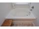 Relaxing bathtub with natural light and a convenient wooden step stool at 110 Serendipity Way, Dallas, GA 30157